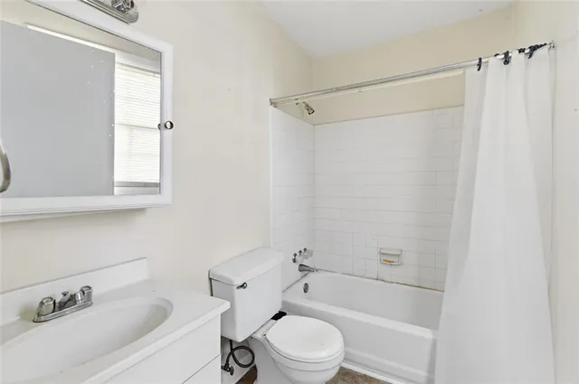 a bathroom with a bathtub shower sink vanity and a toilet