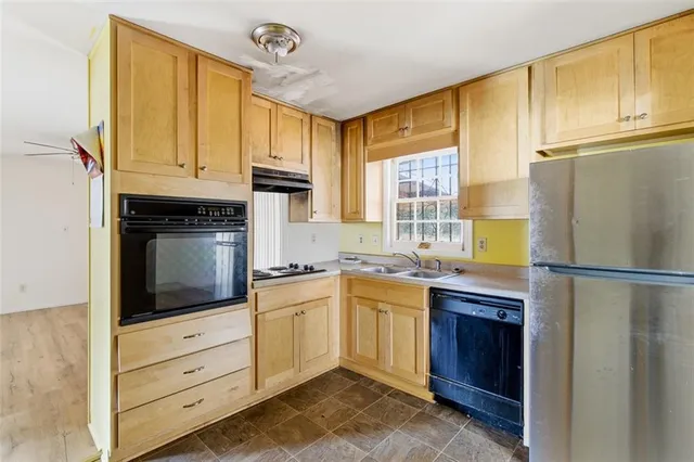 a kitchen with stainless steel appliances granite countertop a refrigerator a stove and a sink with cabinets