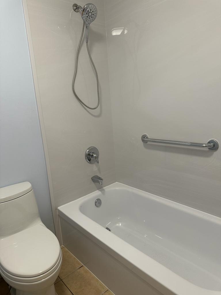 9417 South Ocean Drive, Unit 37 Jensen Beach, FL 34957 - Photo 12 of 18 a white bath tub sitting next to a white toilet and a shower