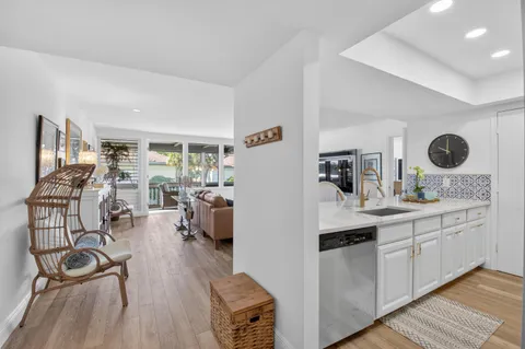 a kitchen with granite countertop a stove and white cabinets