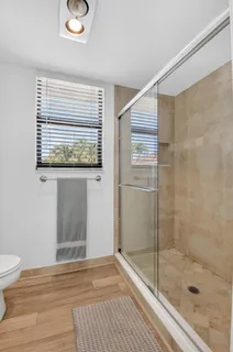 a front view of a house with a garden and palm trees