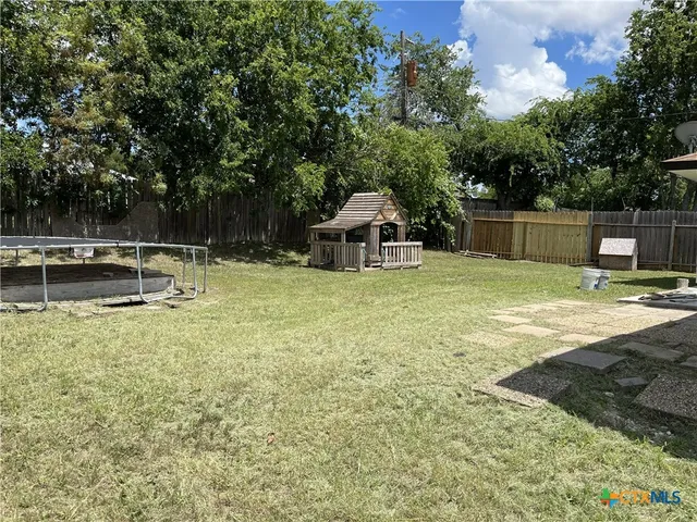 a view of a backyard with swimming pool
