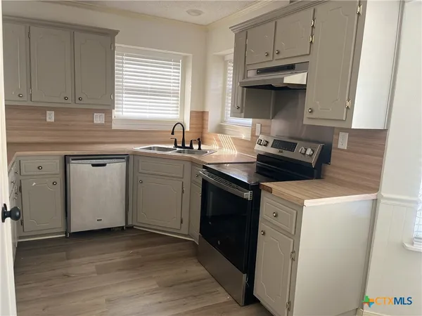 a kitchen with a sink stove and cabinets