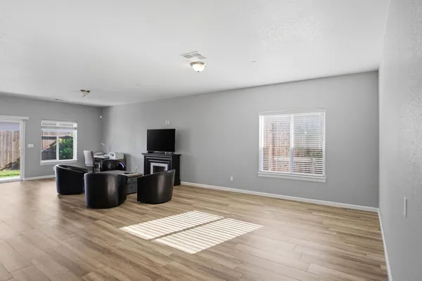 a living room with furniture a flat screen tv and a wooden floor