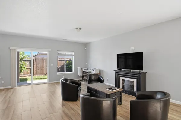 a living room with furniture a flat screen tv and a fireplace