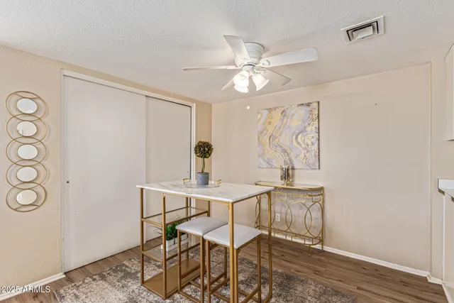 a view of a workspace room with wooden floor table and chairs