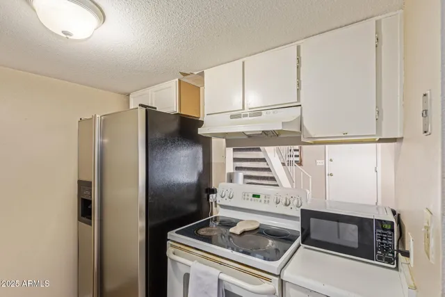a kitchen with stainless steel appliances granite countertop a refrigerator and a stove