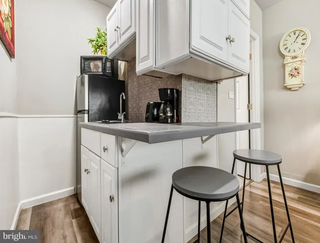 a kitchen with stainless steel appliances a sink cabinets and wooden floor