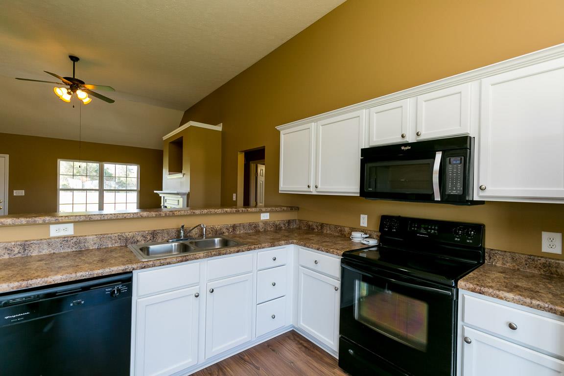 4829 Alsup Mill Road Lascassas, TN 37085 - Photo 7 of 19 a kitchen with granite countertop white cabinets and black appliances
