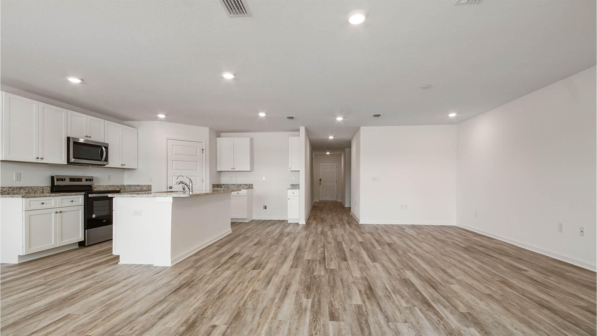59 Foxtrail Run Freeport, FL 32439 - Photo 5 of 20 a open kitchen with kitchen island a sink dishwasher stove and white cabinets with wooden floor