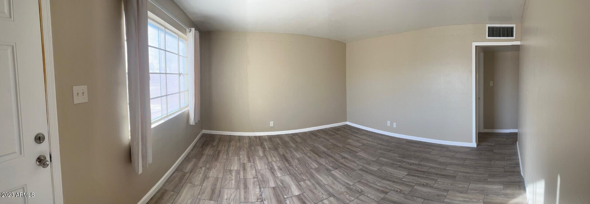 8638 North 8th Street Phoenix, AZ 85020 - Photo 4 of 12 a view of an empty room with wooden floor and a window