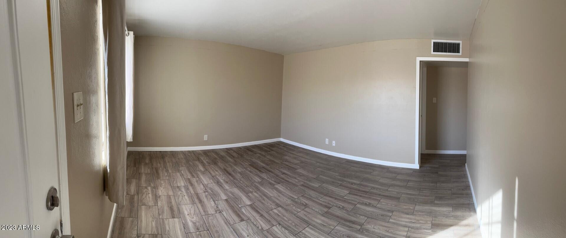 8638 North 8th Street Phoenix, AZ 85020 - Photo 10 of 12 a view of an empty room with wooden floor and a window