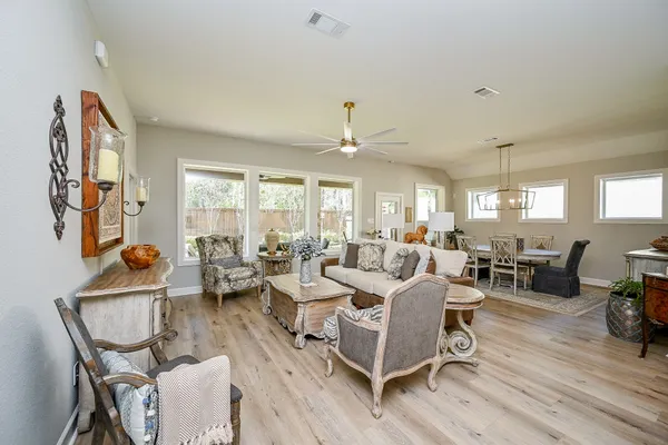 a kitchen with stainless steel appliances granite countertop a kitchen island hardwood floor sink stove dining table and chairs