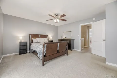 a bedroom with a bed and a ceiling fan