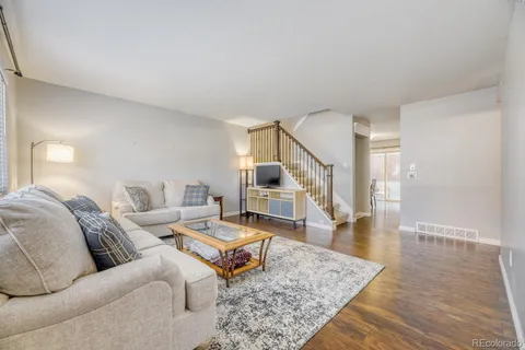 a living room with furniture and wooden floor