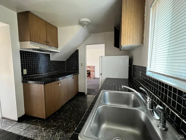 a kitchen with a sink and a stove top oven