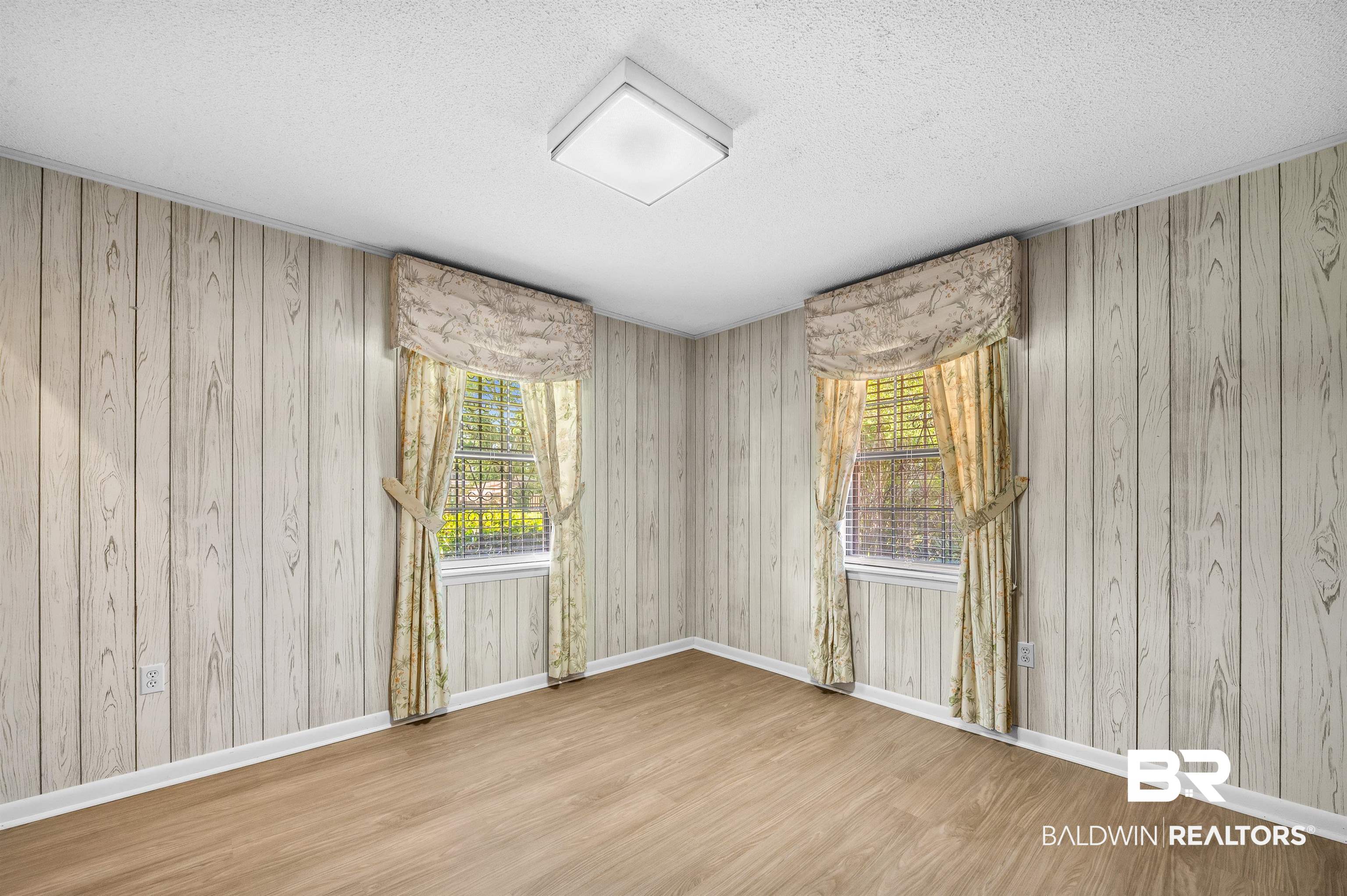 610 East Walker Avenue Foley, AL 36535 - Photo 27 of 38 Unfurnished room with wood finished floors, a textured ceiling, plenty of natural light, and wooden walls
