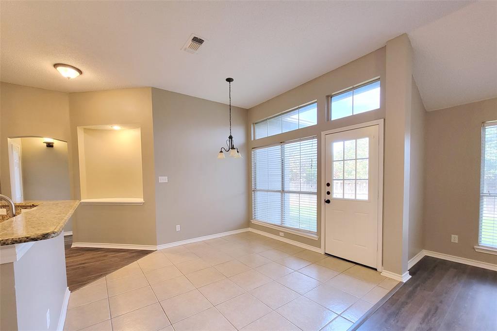 1604 Knoll Ridge Circle Corinth, TX 76210 - Photo 24 of 37 Dining space featuring tiled flooring, a transom window, a glass-paneled exterior door, a built-in display nook with accent lighting, and a multi-light chandelier
