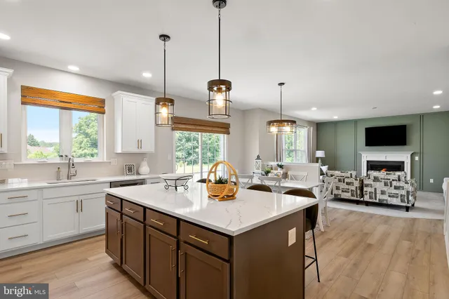 a kitchen with a stove a sink dishwasher a dining table and chairs with wooden floor