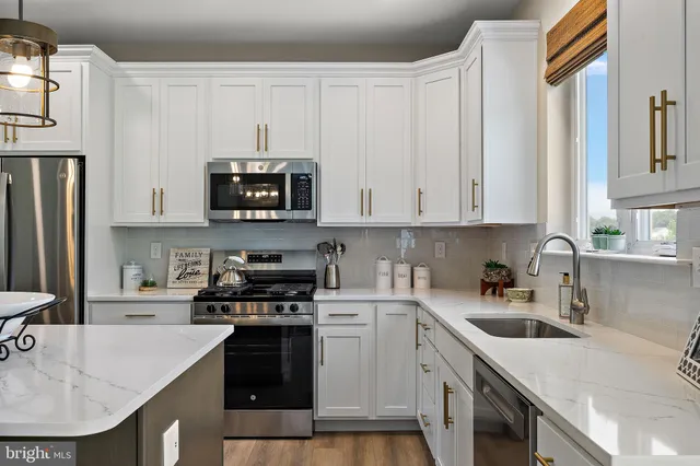 a kitchen with stainless steel appliances granite countertop a sink a stove and a microwave