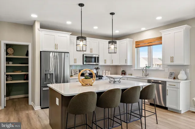 a kitchen with a dining table chairs refrigerator and cabinets