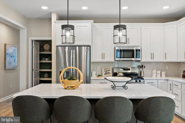 a kitchen with stainless steel appliances granite countertop a sink a microwave refrigerator and cabinets