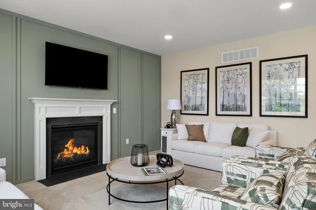 a living room with furniture a fireplace and a flat screen tv