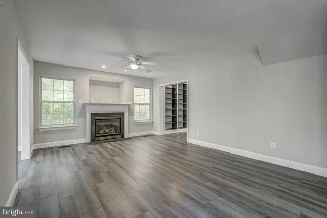 a view of a big room with wooden floor and windows
