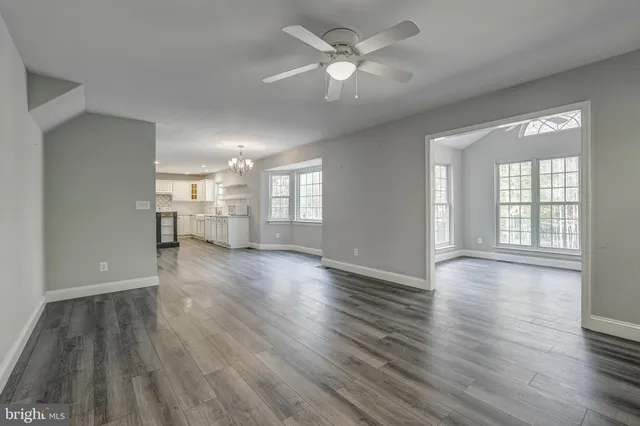 a view of an empty room with window and wooden floor