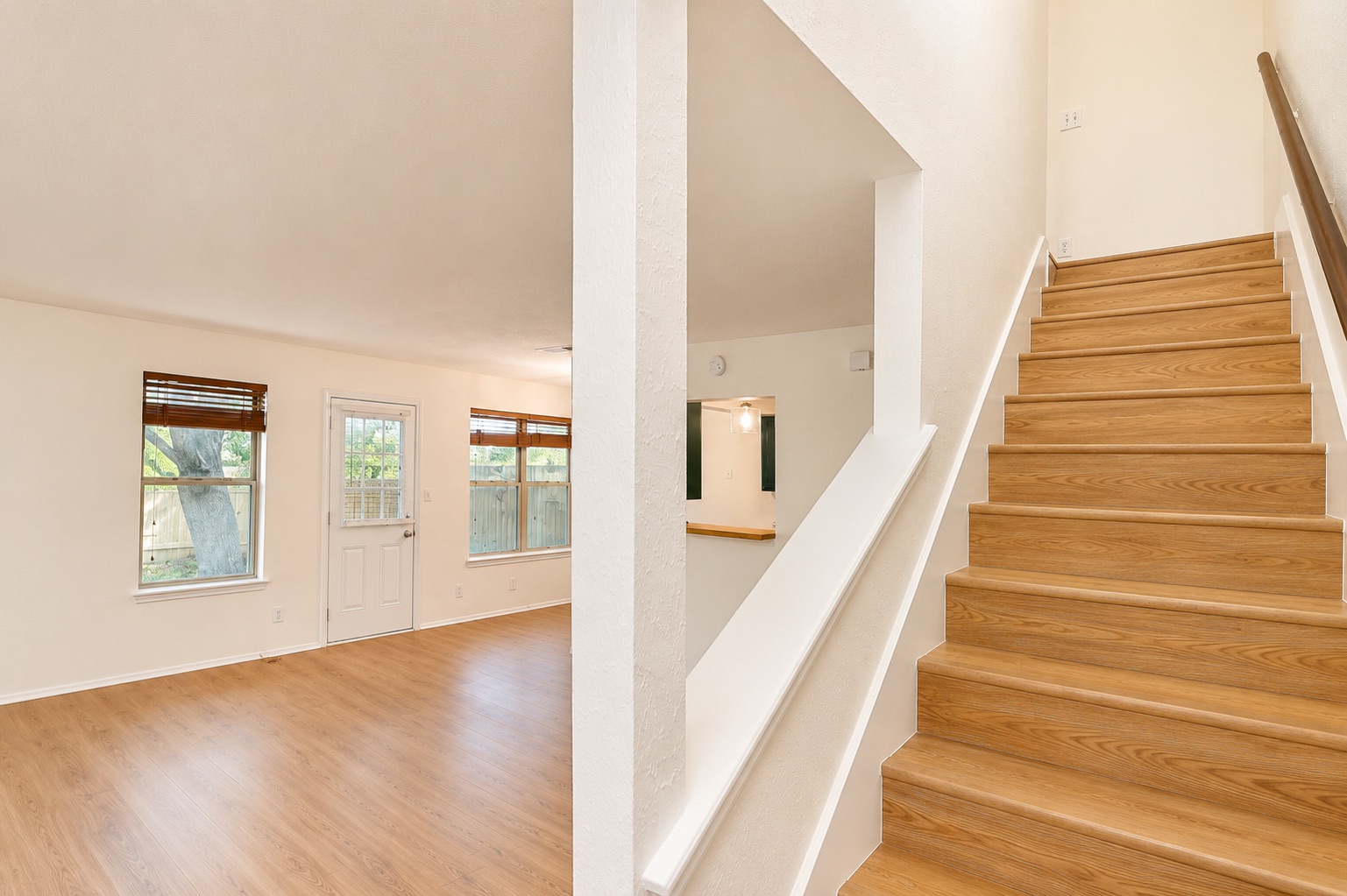 8807 Springmail Circle, Unit A Austin, TX 78729 - Photo 36 of 40 Natural light illuminates this inviting living space, showcasing rich hardwood flooring and a functional stairway.
