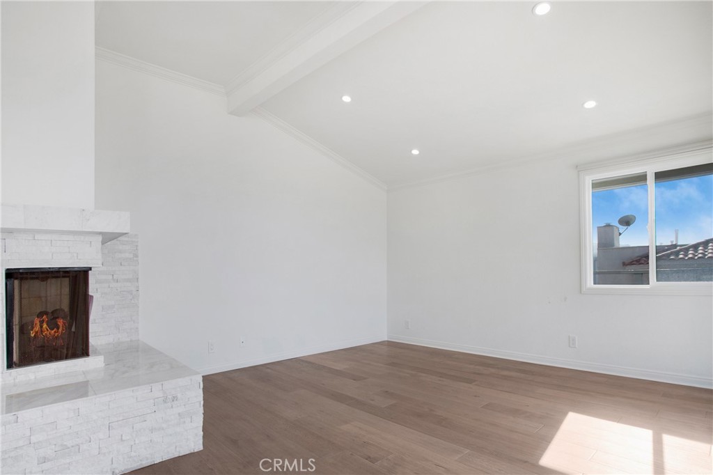 127 40th Street Manhattan Beach, CA 90266 - Photo 11 of 29 a view of an empty room with wooden floor and a fireplace