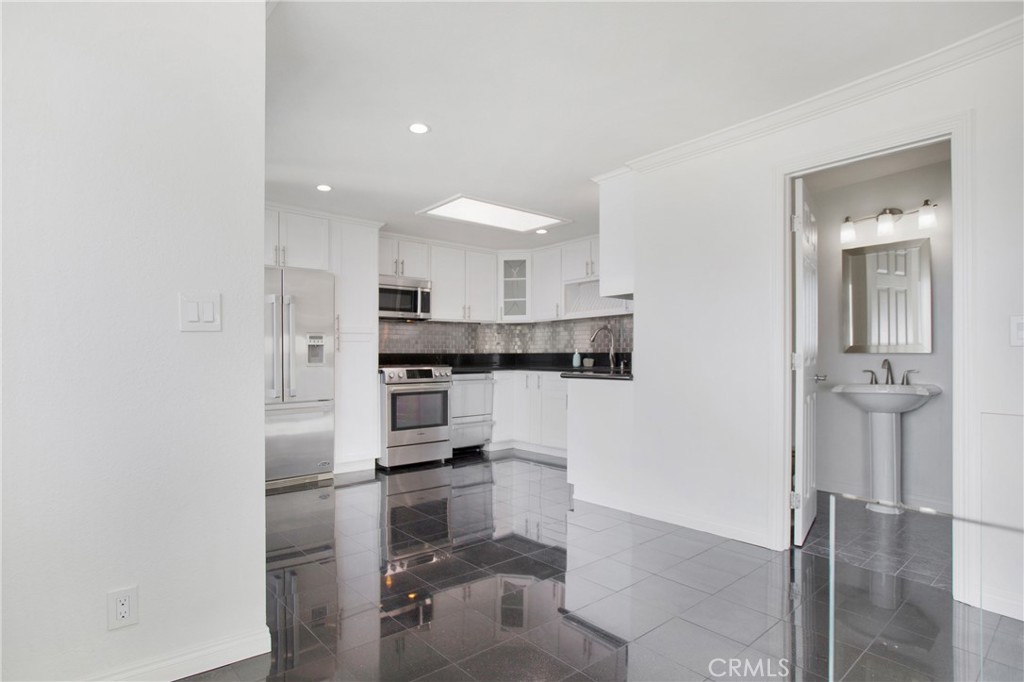 127 40th Street Manhattan Beach, CA 90266 - Photo 9 of 29 a kitchen with stainless steel appliances kitchen island granite countertop a refrigerator and a sink