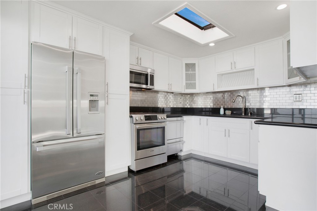 127 40th Street Manhattan Beach, CA 90266 - Photo 10 of 29 a kitchen with granite countertop white cabinets and stainless steel appliances