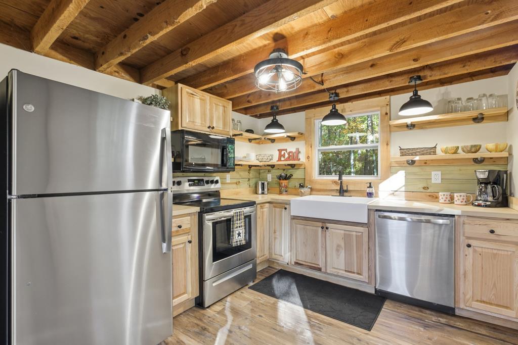5240 Squirrel Hunting Road Blairsville, GA 30512 - Photo 13 of 40 a kitchen with stainless steel appliances granite countertop a refrigerator a sink and white cabinets