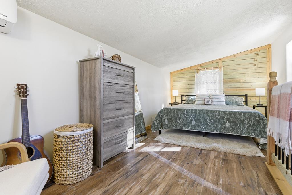 5240 Squirrel Hunting Road Blairsville, GA 30512 - Photo 21 of 40 a bedroom with a bed and a wooden floor