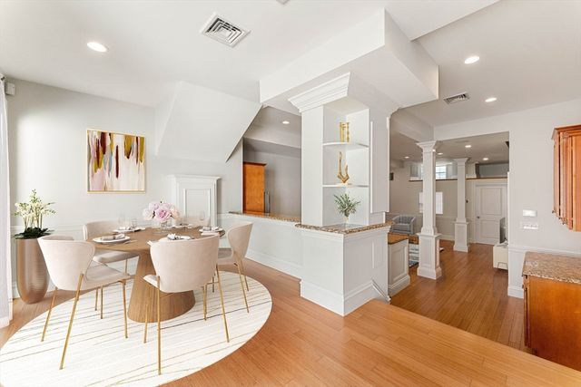a living room with furniture a wooden floor and kitchen view