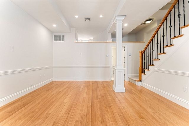 a view of empty room with wooden floor