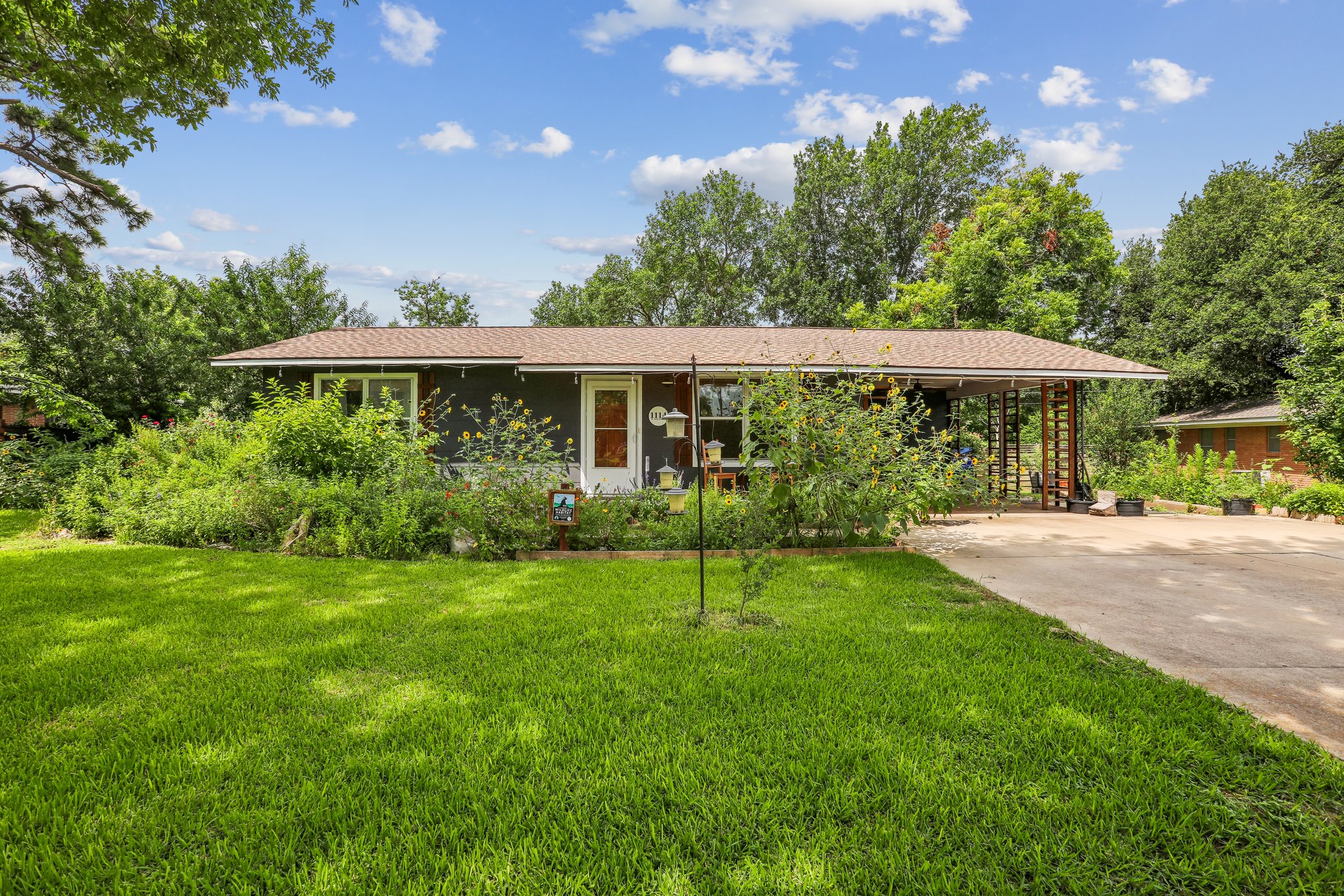 A welcoming front exterior with mature landscaping and ample outdoor space.