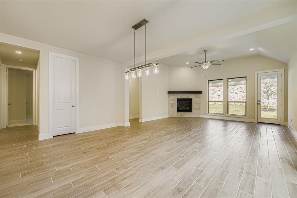 130 Pecan Lane Rhome, TX 76078 - Photo 8 of 28 Unfurnished living room with recessed lighting, light wood finished floors, a premium fireplace, lofted ceiling, and ceiling fan