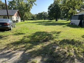 a view of a house with a big yard and large trees
