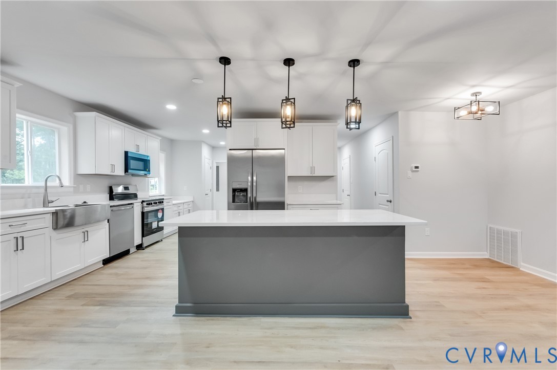 7906 Battlefield Park Road Henrico, VA 23231 - Photo 12 of 42 a large white kitchen with stainless steel appliances