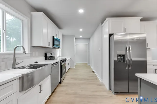 a kitchen with stainless steel appliances a stove a sink and a microwave