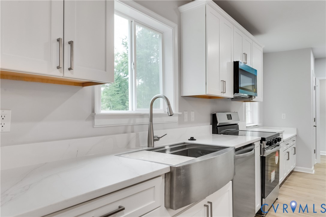 7906 Battlefield Park Road Henrico, VA 23231 - Photo 17 of 42 a kitchen with stainless steel appliances a stove a sink and a microwave