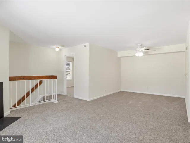 an empty room with a ceiling fan and entryway