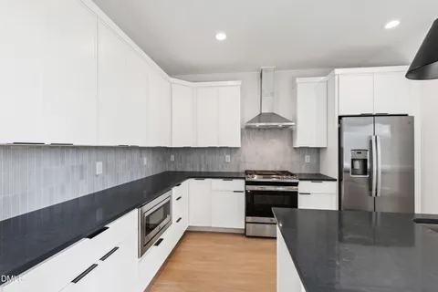 a kitchen with stainless steel appliances kitchen island a sink a stove and a window