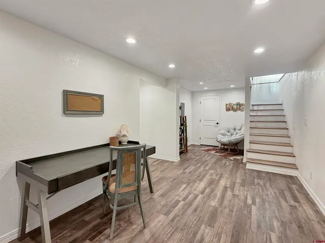 a view of a hallway with wooden floor and furniture