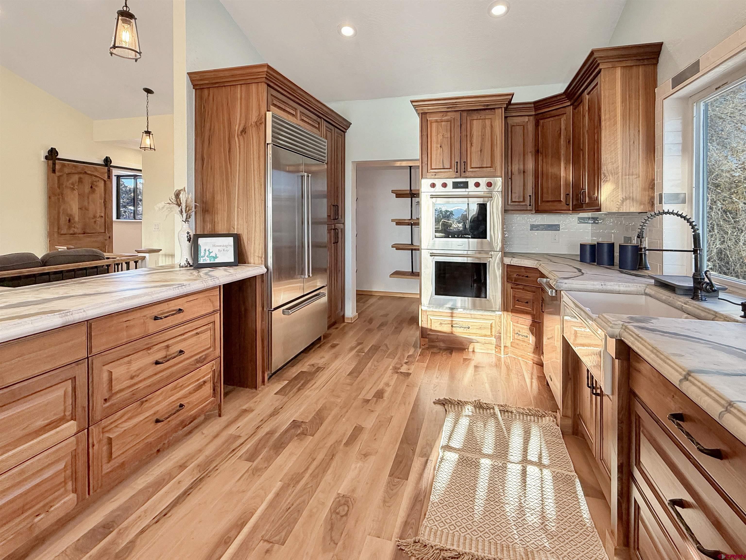 27425 Rd P.7 Dolores, CO 81323 - Photo 7 of 45 a kitchen with granite countertop wooden floors wooden cabinets and stainless steel appliances