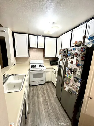 a kitchen with white cabinets and white appliances