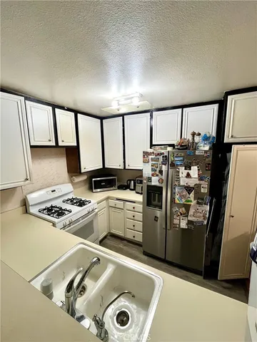 a kitchen with a refrigerator and a stove top oven