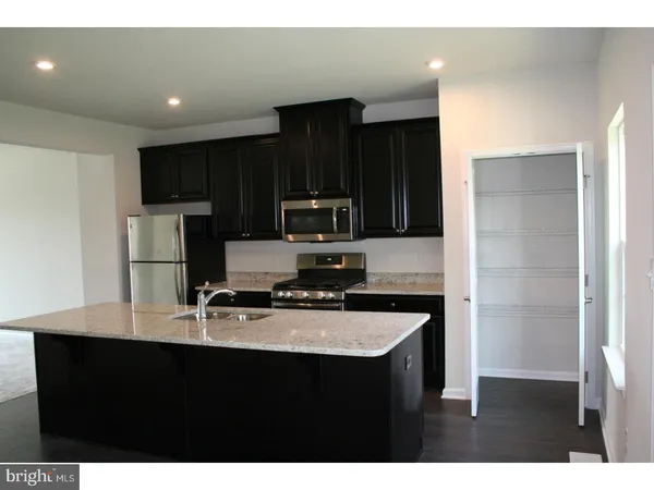 a kitchen with kitchen island a counter top space cabinets and stainless steel appliances
